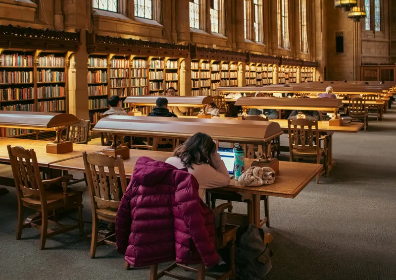 Estudiante leyendo en la biblioteca Suzzallo, Universidad de Washington